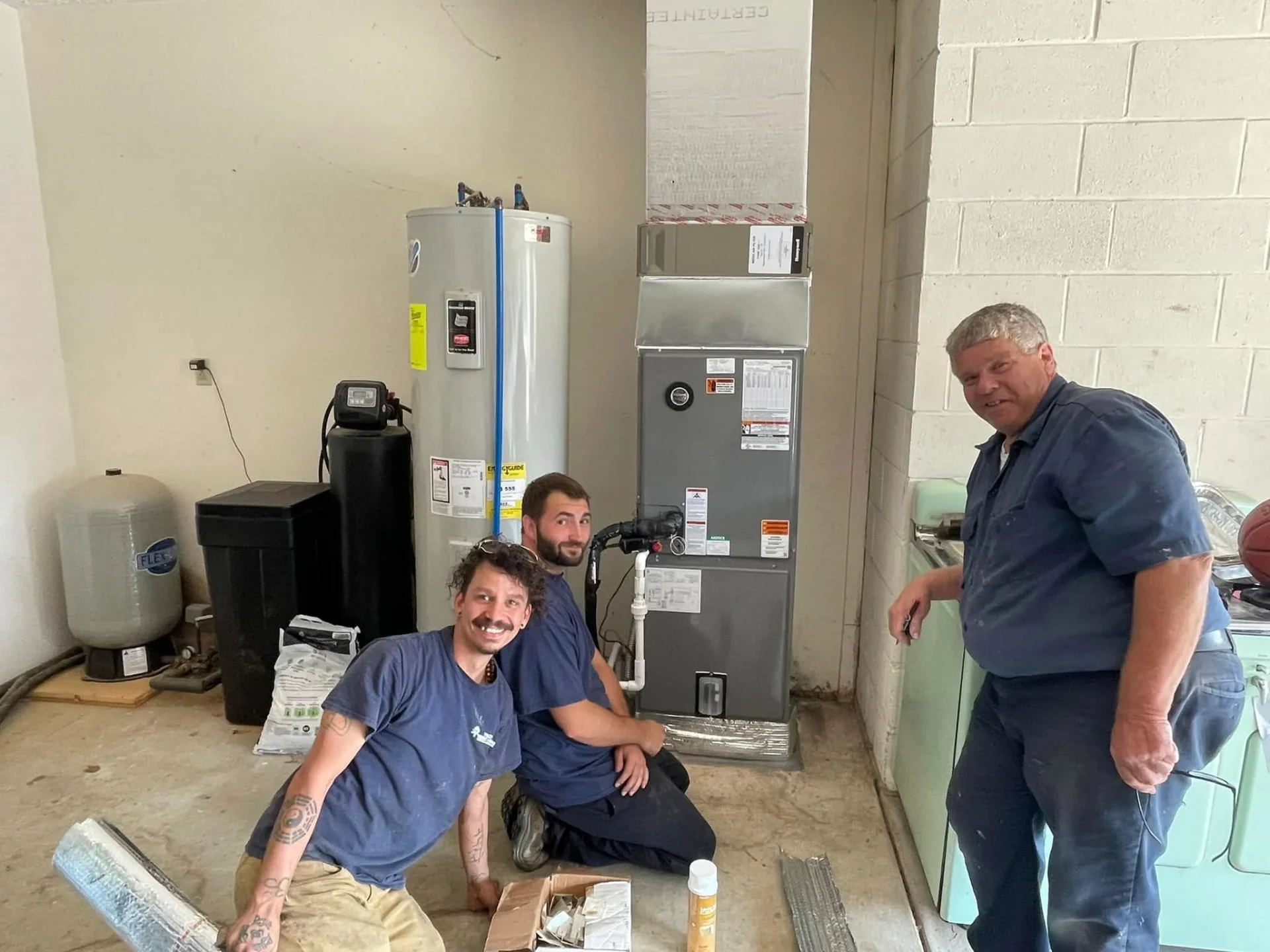 Polley's Perfect Seasons technicians next to a freshly installed furnace and tank water heater in Plainfield, IN